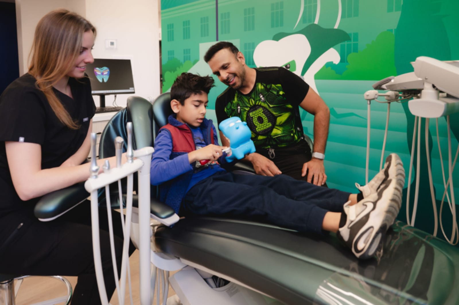 Dental team member engaging with child patient during exam in treatment area