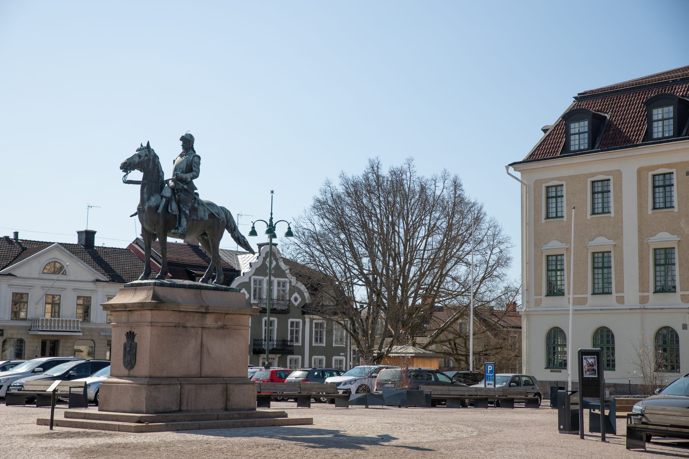 Ryttarstaty på torg i centrala Eksjö med historiska byggnader i bakgrunden