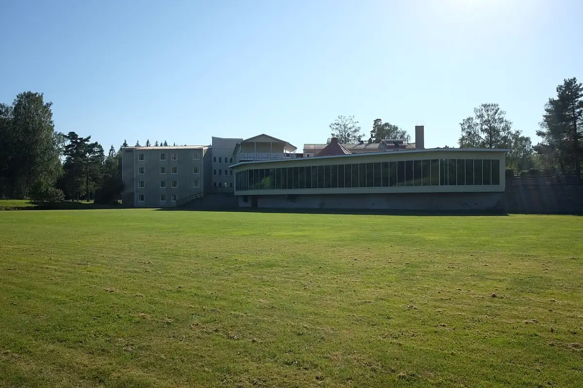 Öppen gräsyta i Hindås framför större byggnad