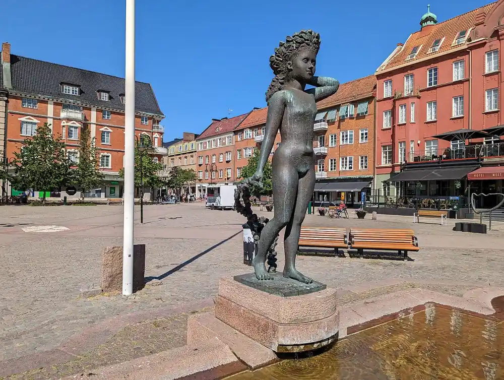 Torg i Hässleholm med skulptur och tegelhus