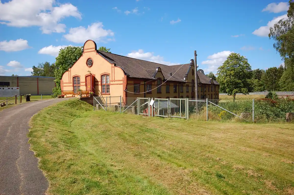 Större byggnad i Lessebo vid gångväg och gräs