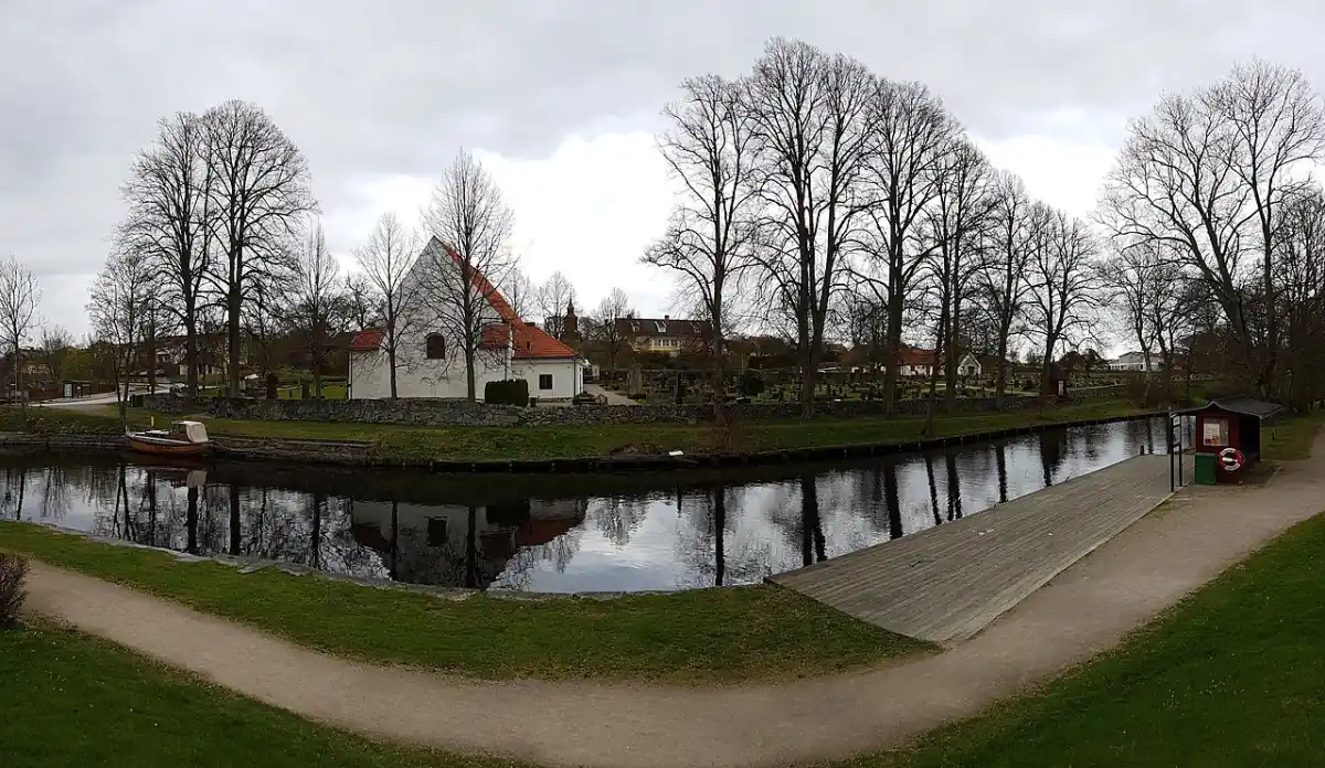 Bro över vatten i Nättraby med kyrka i bakgrunden