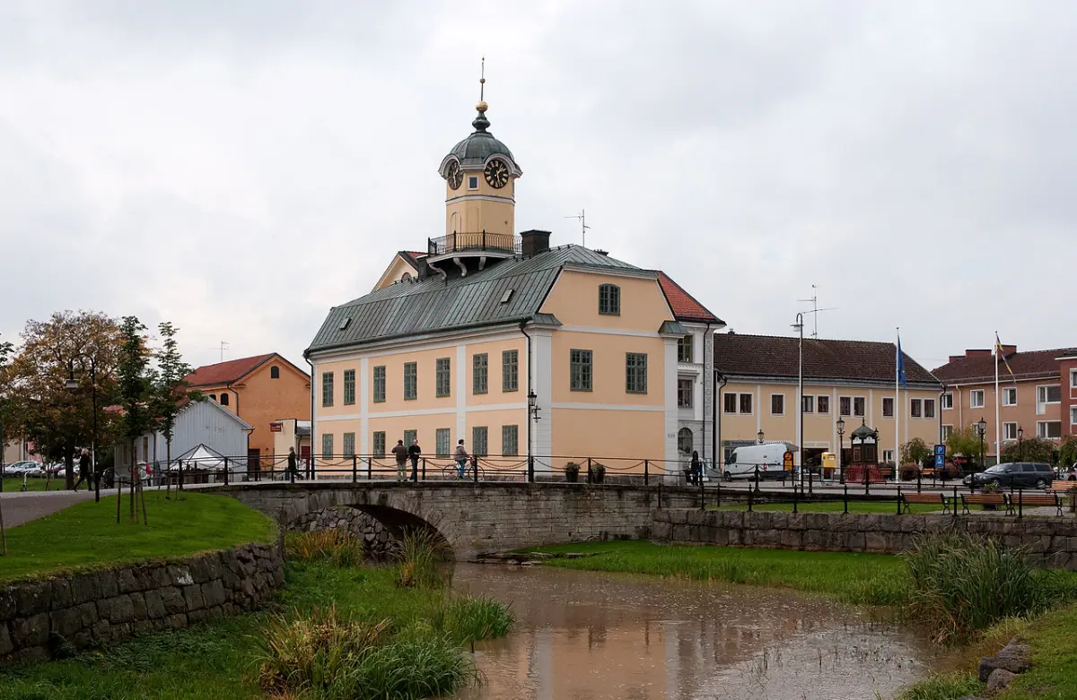 Byggnad vid kanal i Söderköping med gräsmatta