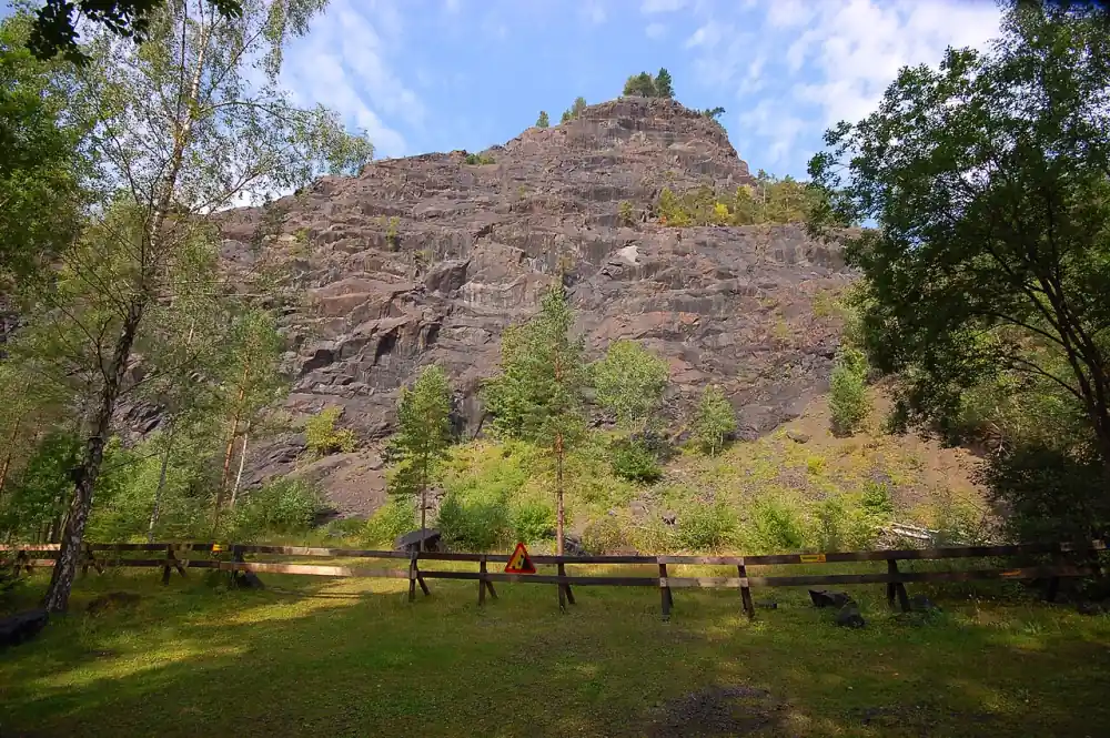 Bergklippa i Taberg med träd och öppet gräsområde