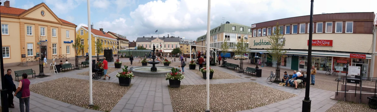 Torg i Vimmerby med butiker och gående