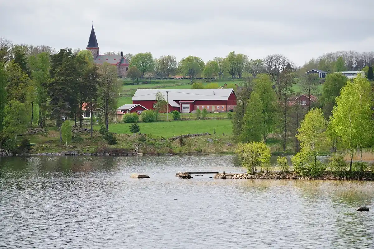 Sjönära bebyggelse i Vårgårda med kyrktorn i bakgrunden