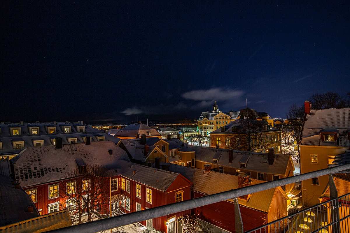 Kvällsutsikt över centrala Jönköping med upplysta byggnader och takåsar