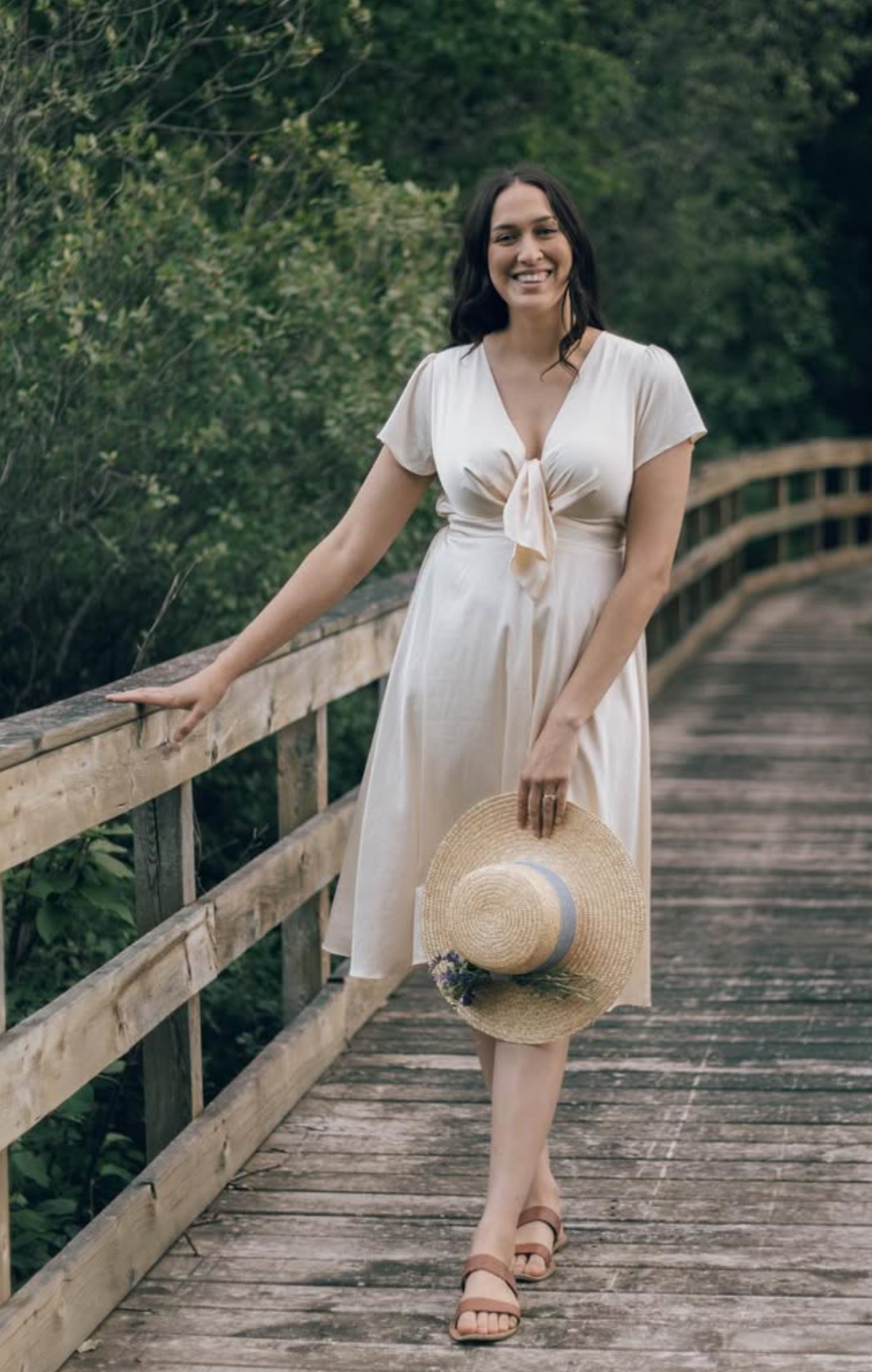 Image of Kaycee Packard holding a hat on a brigde