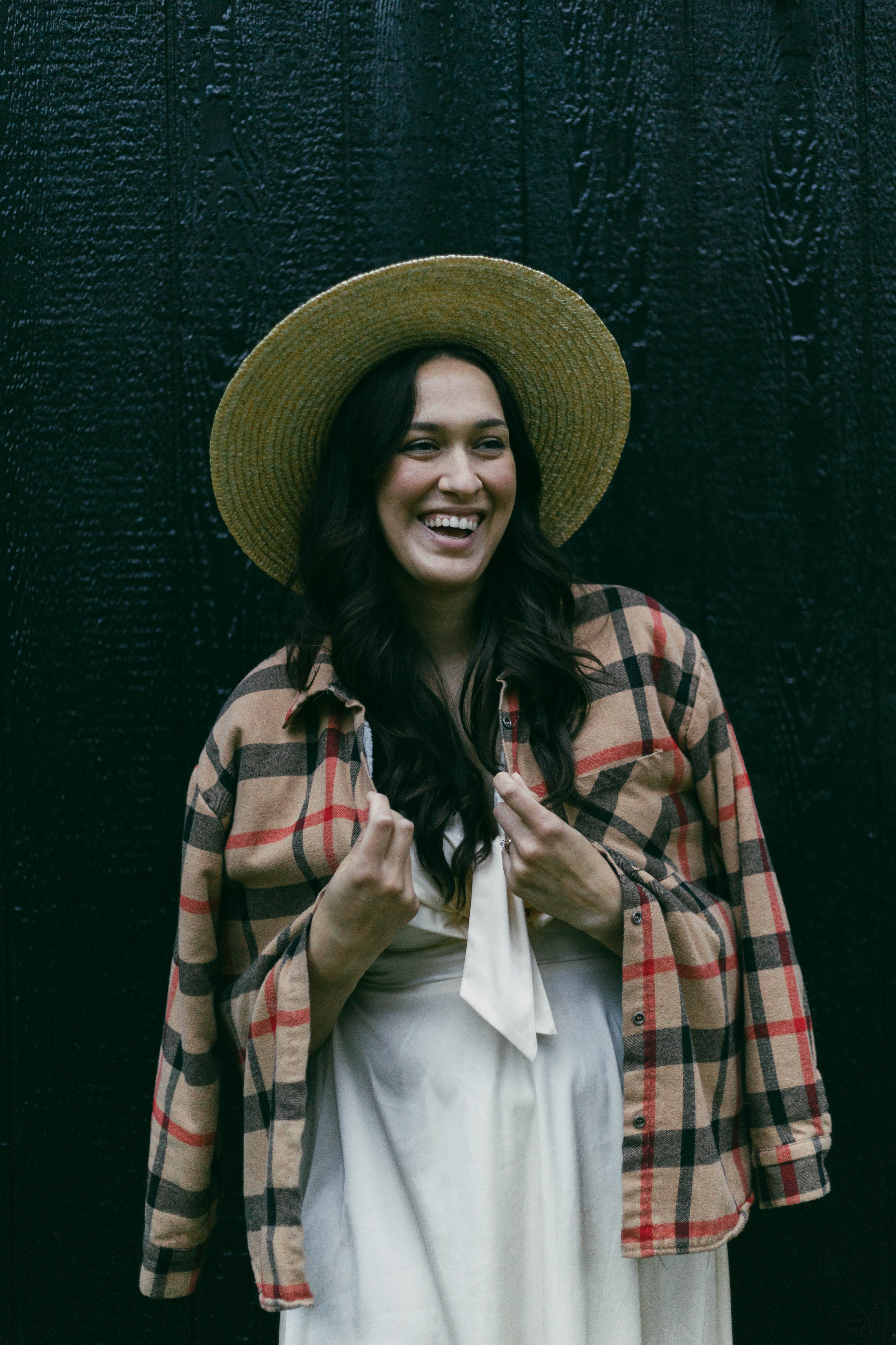 Image of Kaycee smiling with a flannel over a white dress