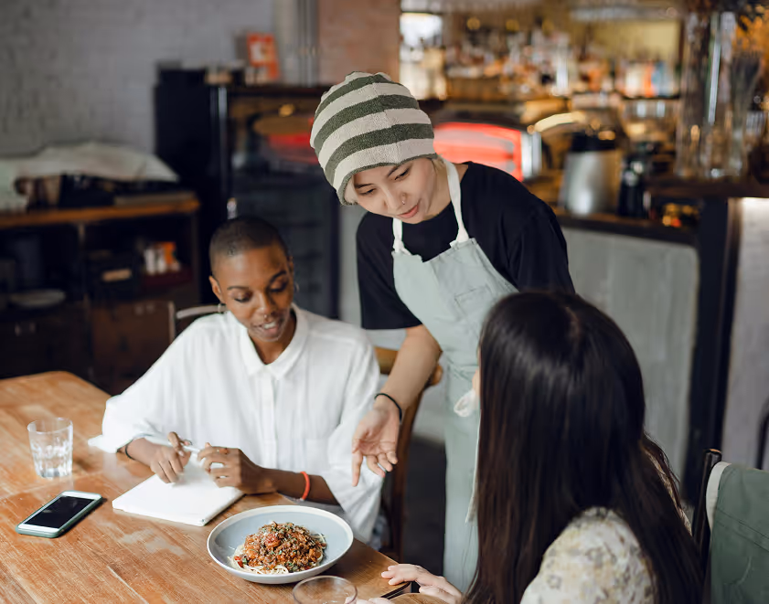 woman serving guests at restaurant table