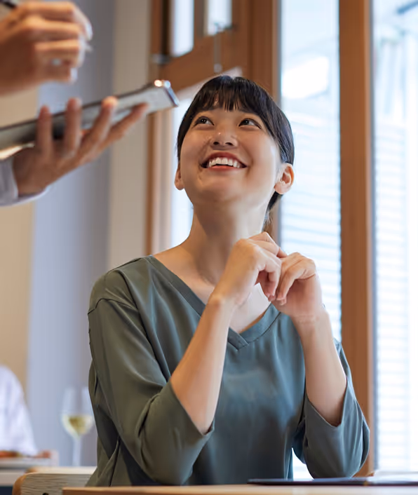 woman sitting at a table ordering food