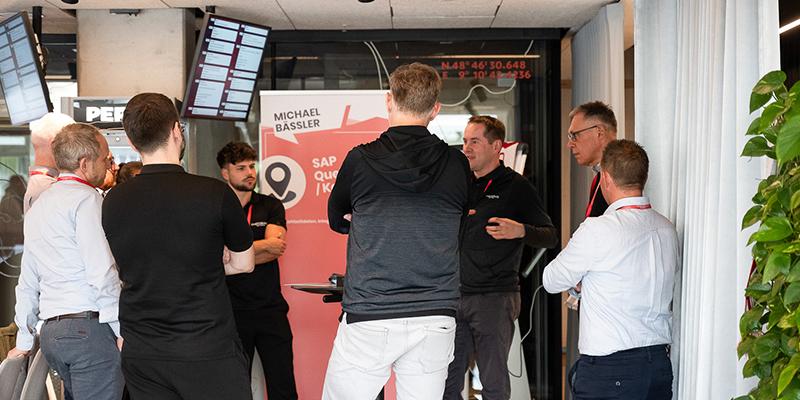 Teilnehmende des Community Days von Theobald Software stehen zusammen und reden.