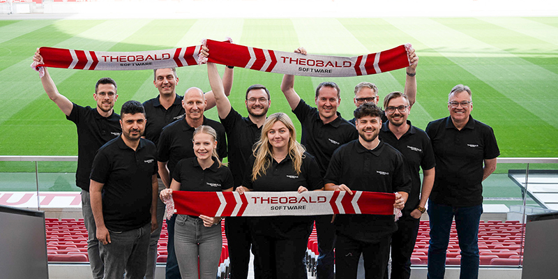 Teilnehmende des Community Days von Theobald Software halten einen Banner hoch.