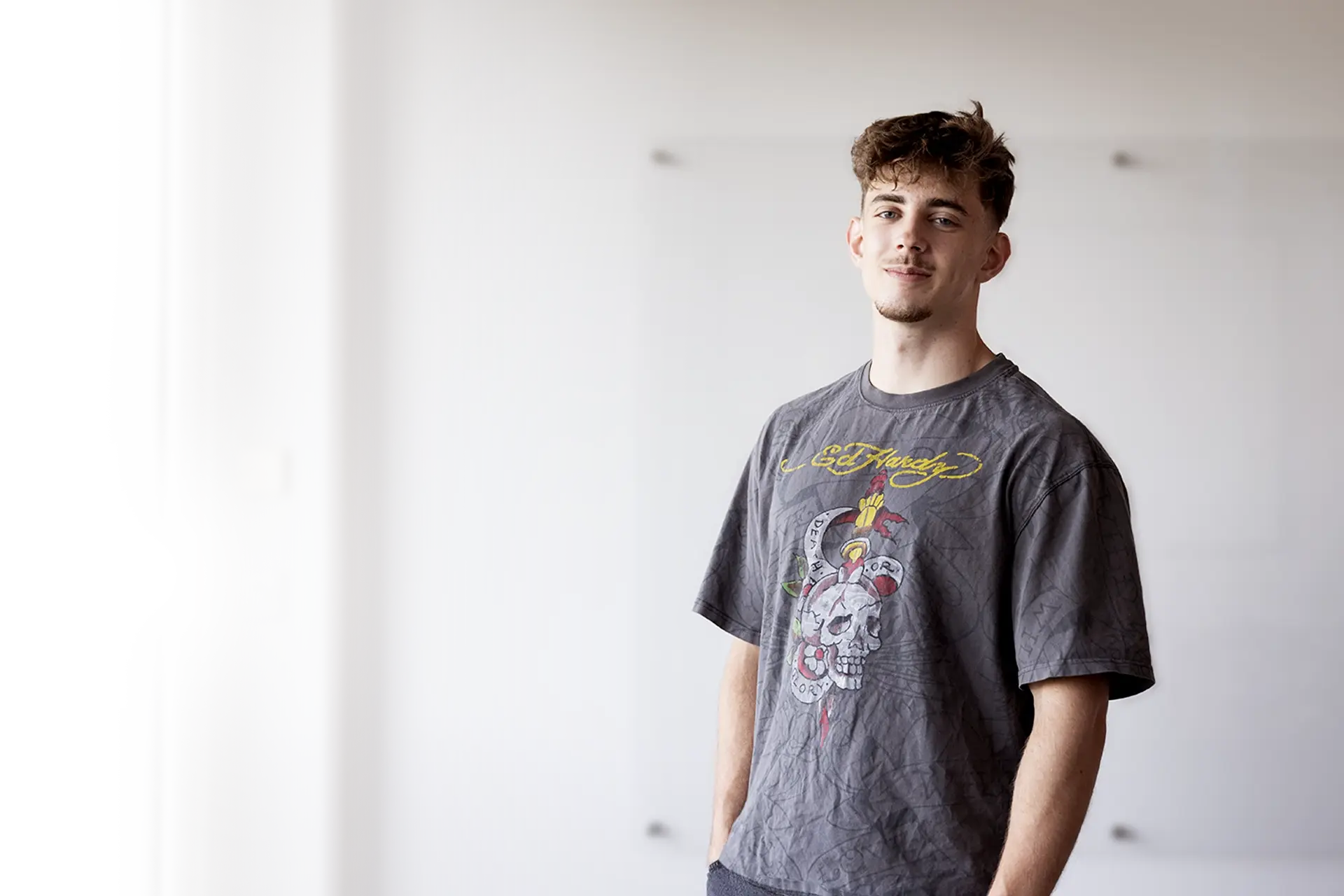 Junger Mann in grauem T-Shirt.