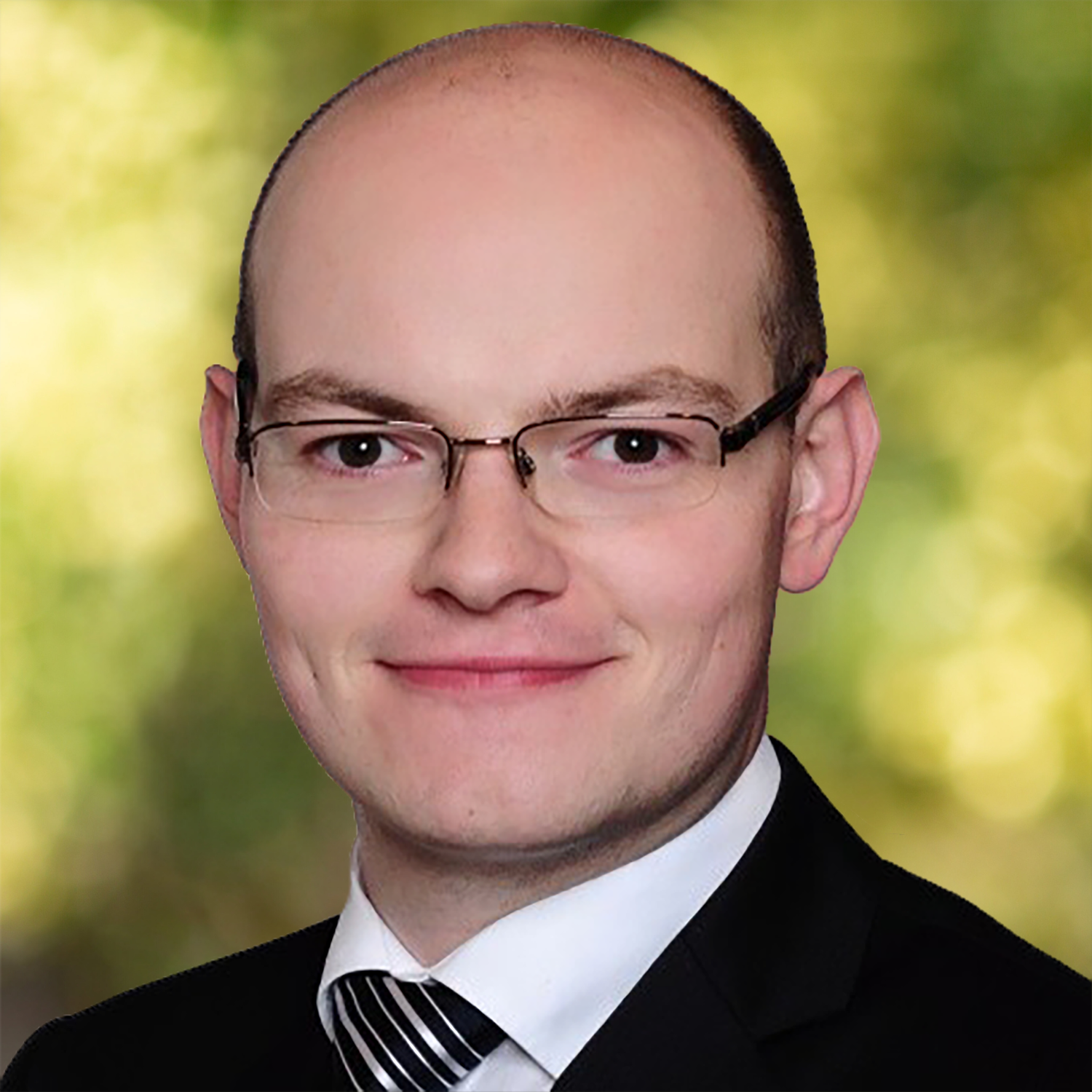 Mann mit Brille und Anzug.