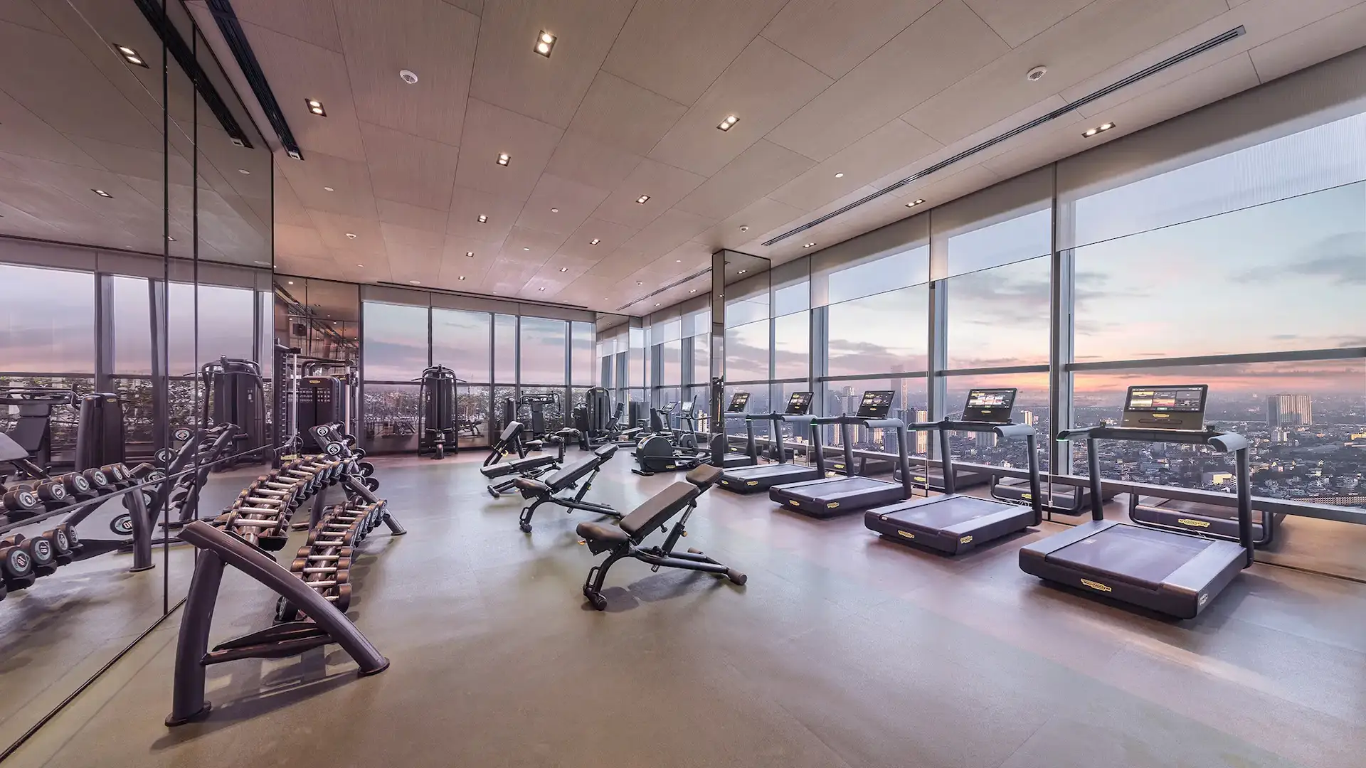 Phòng gym trên cao tại The Marq với vách kính toàn cảnh và tầm nhìn ra thành phố