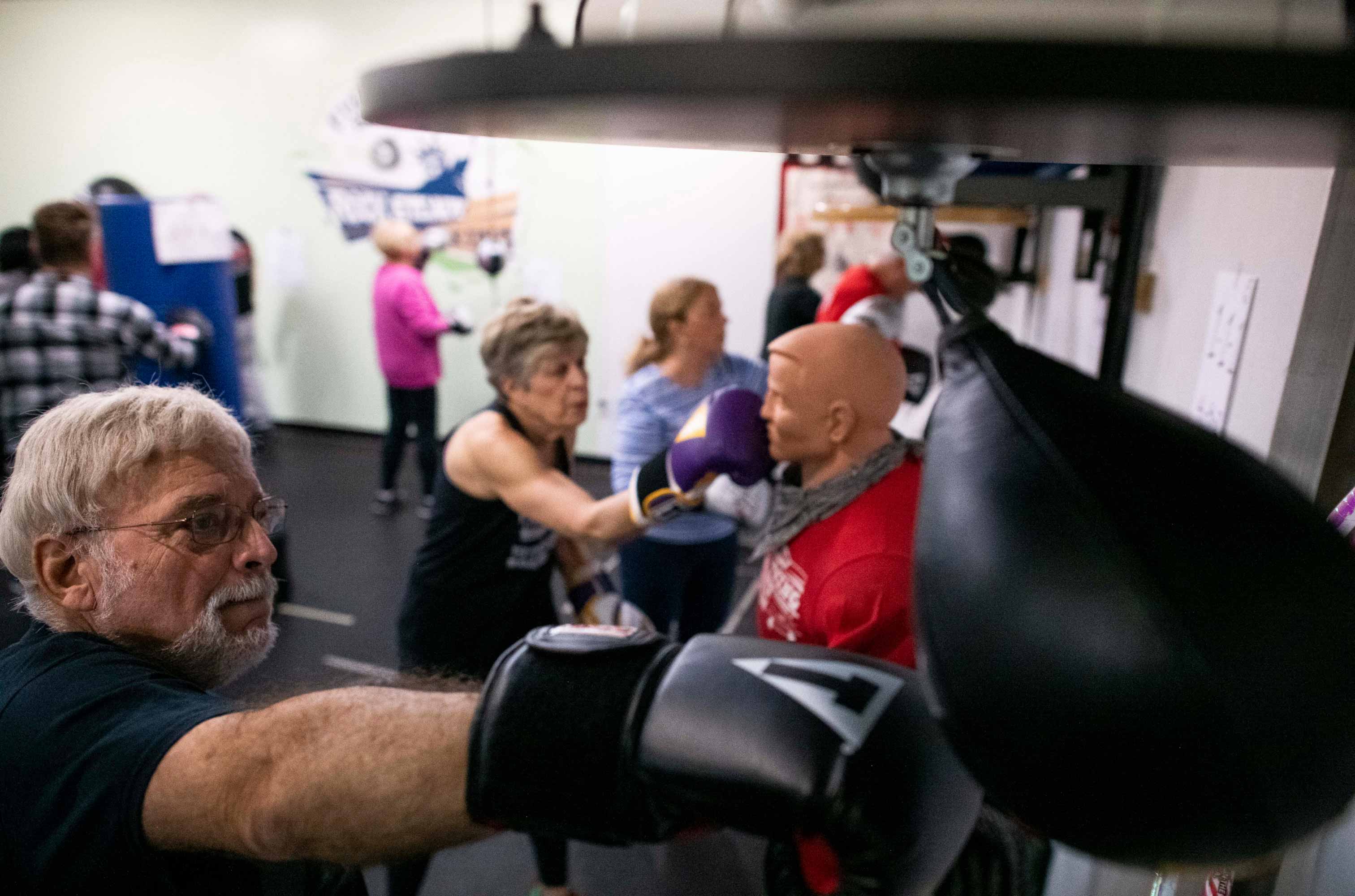 Man hitting an uppercut at a boxing class. 