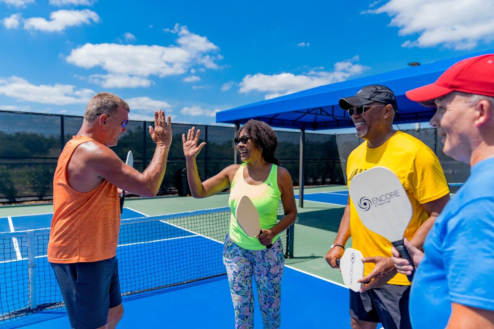 Residents celebrating together on the tennis court at Encore at Tradition in Port St. Lucie