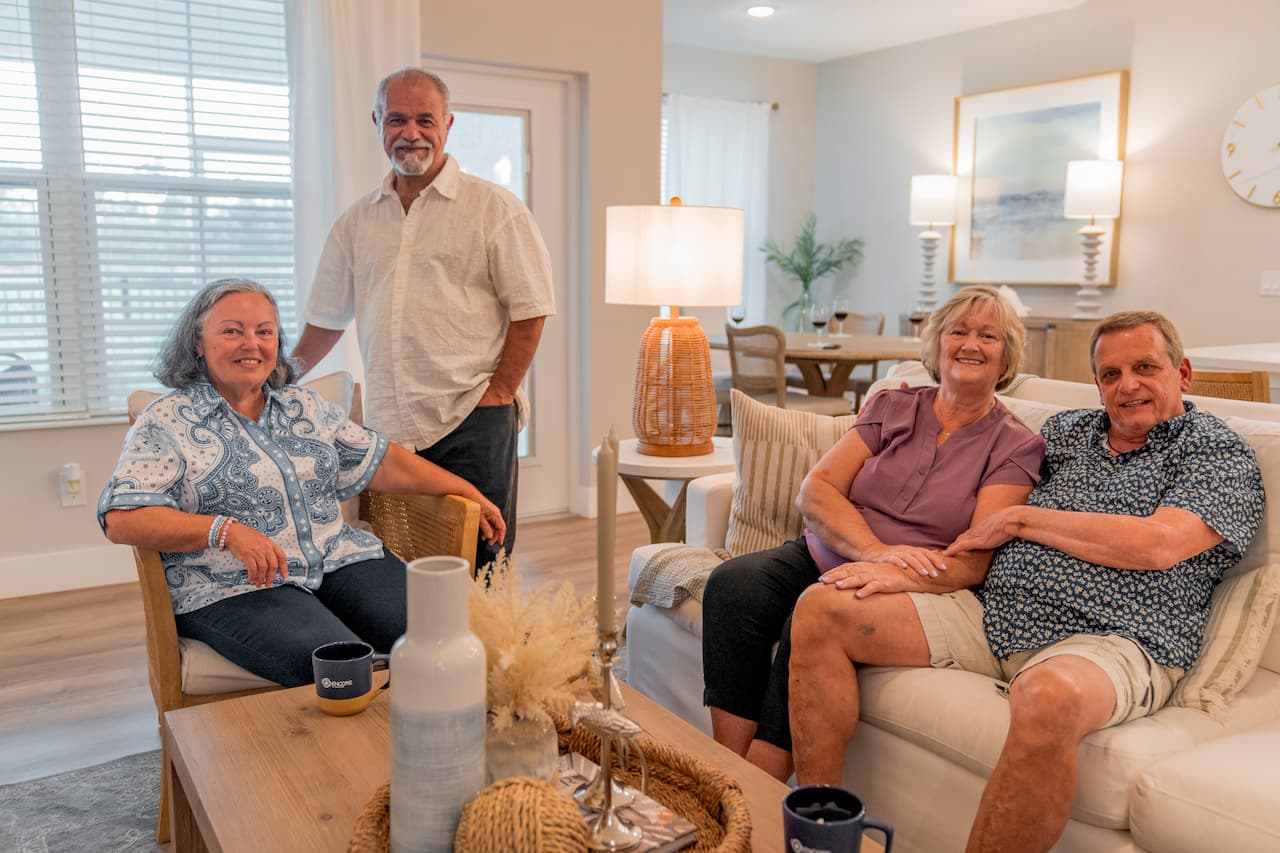 Residents relaxing together inside a modern villa at Encore at Tradition in Port St. Lucie, Florida, showcasing the comfort, connection, and maintenance-free lifestyle of a 55+ active adult rental community.