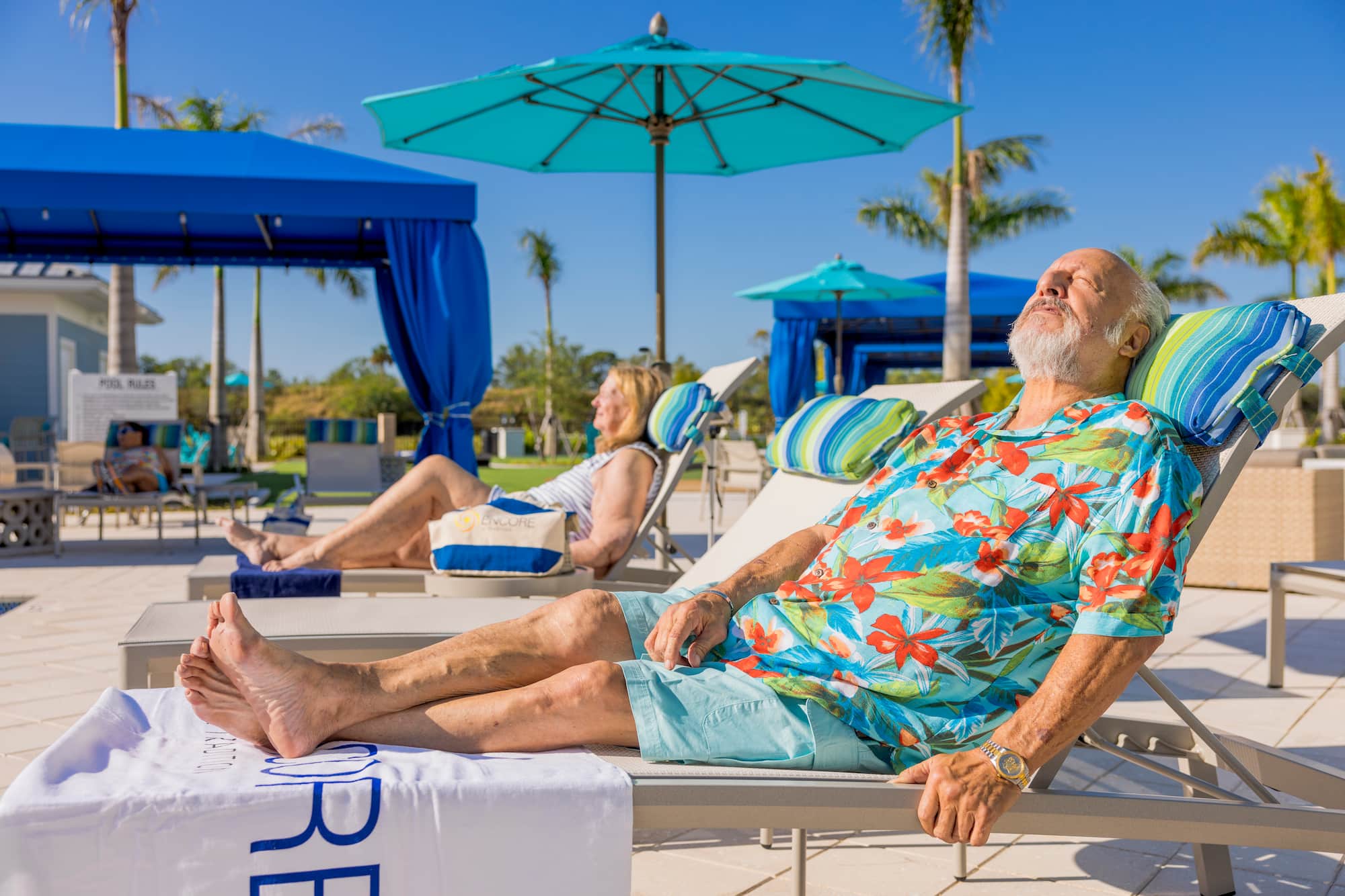 Residents relaxing by the resort-style pool at Encore at Tradition in Port St. Lucie, Florida, enjoying the carefree lifestyle and luxury amenities offered in this 55+ active adult rental community. 