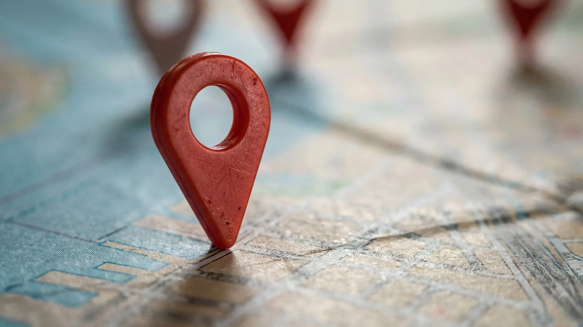 Roter Standort-Pin auf einer Straßenkarte (Nahaufnahme, unscharfer Hintergrund).