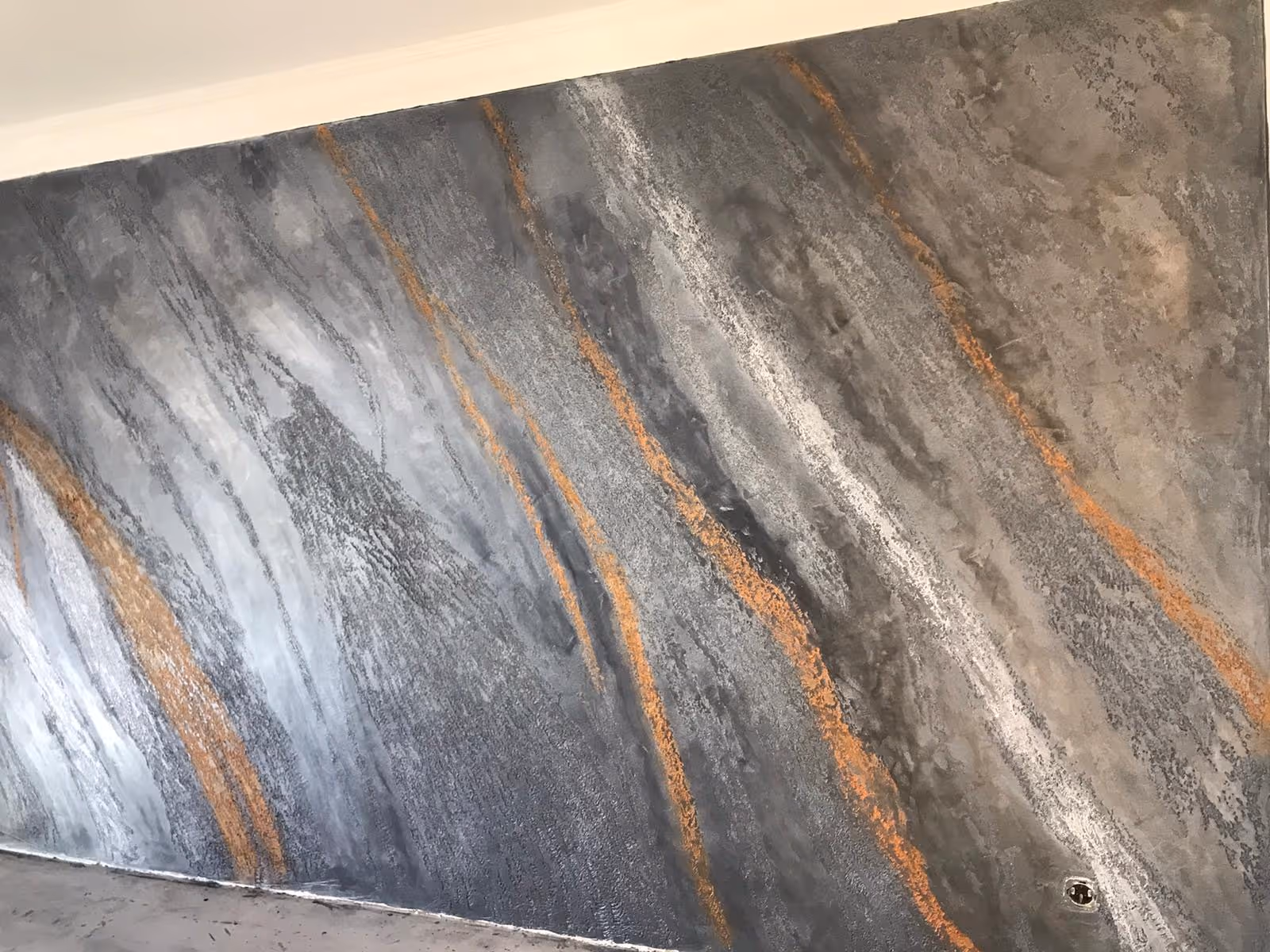 Großflächige Wandgestaltung mit strukturierter Effekttechnik in Grau und Rostoptik – umgesetzt vom Malerbetrieb Brückner in Mainz