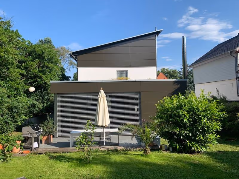 Moderne Fassadengestaltung mit dunklem Anbau in einem Wohngebiet in Mainz – umgesetzt vom Malerbetrieb Brückner