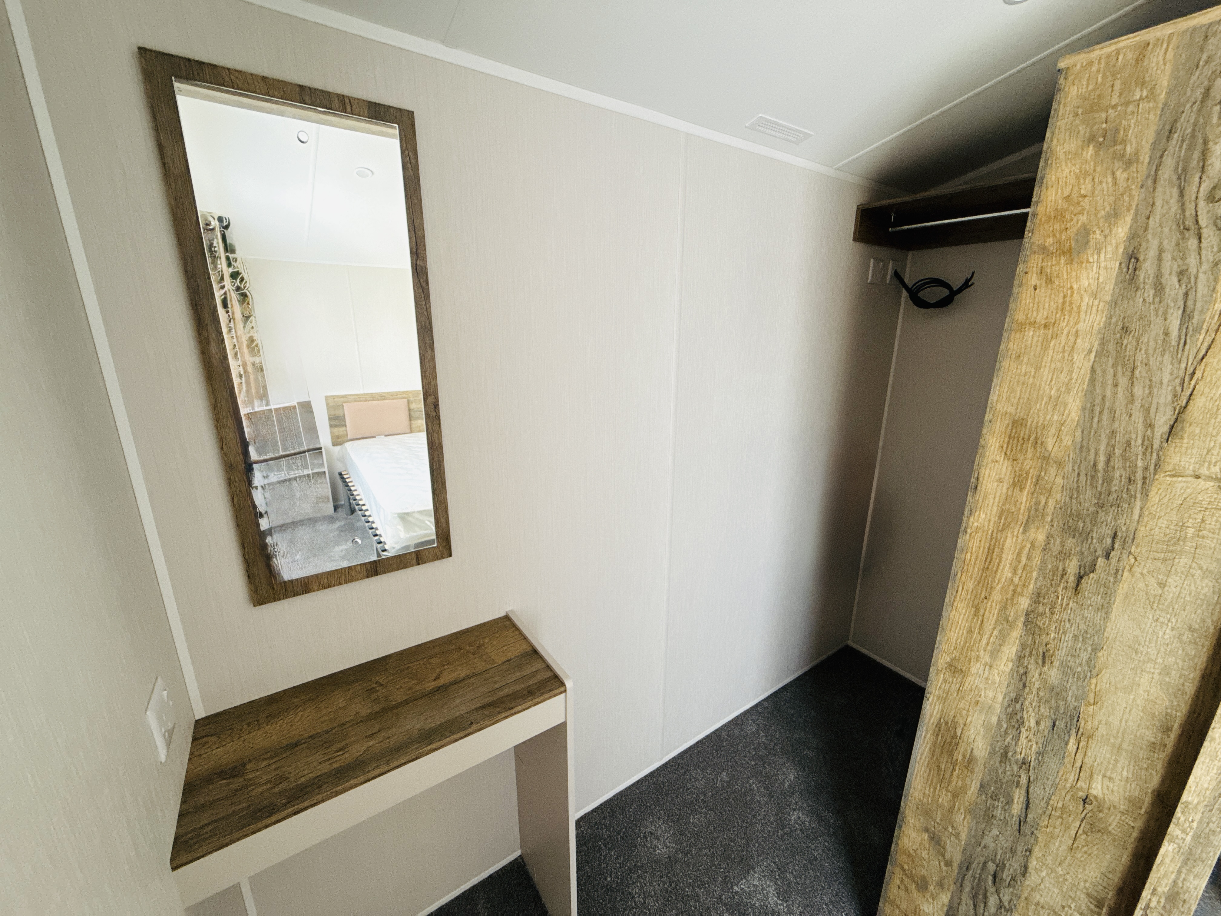 Entryway with wooden-framed mirror, bench, and rustic closet storage