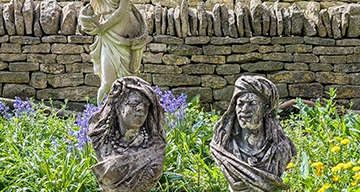 Stone statues in front of dry stone wall