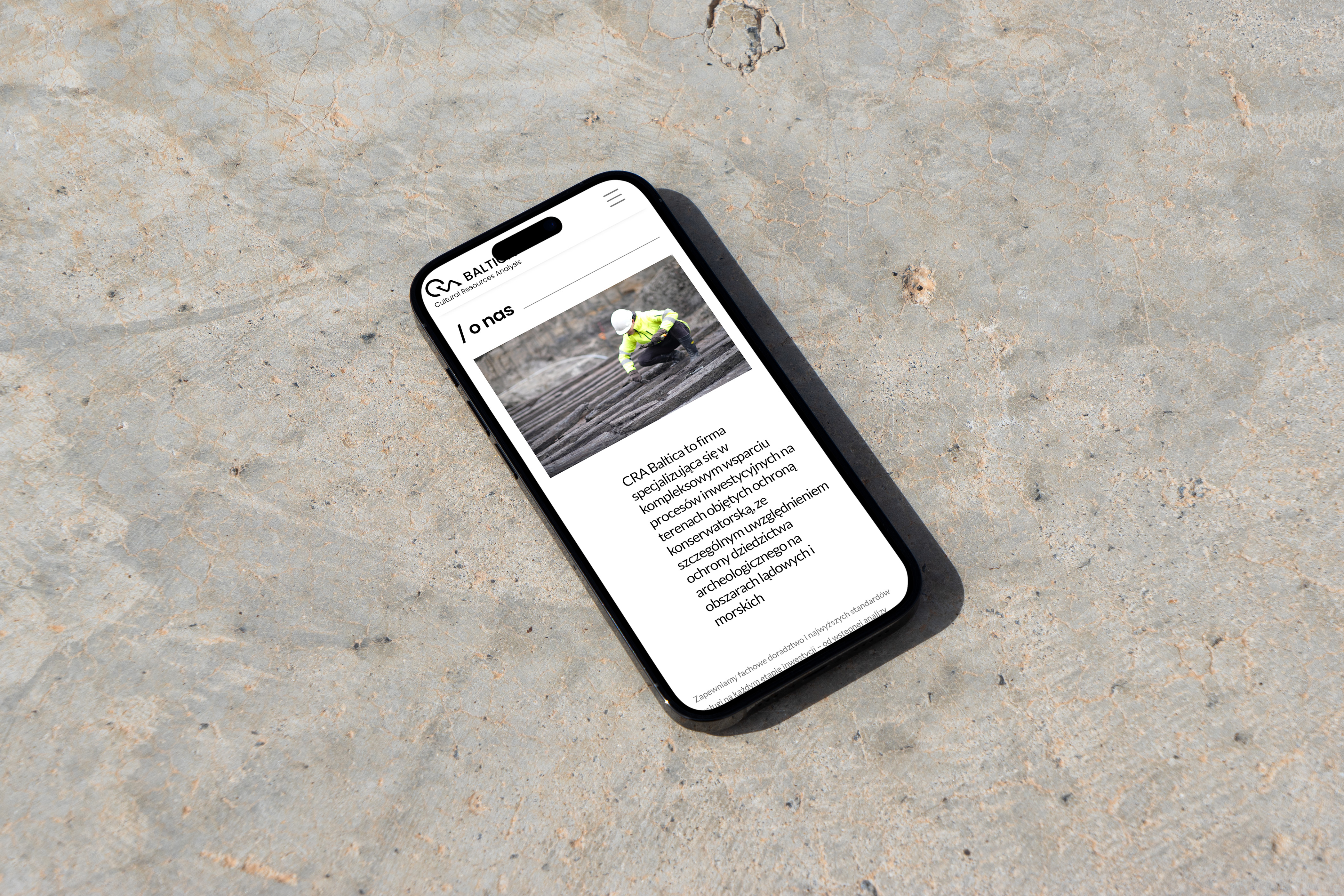 Mobiltelefon med knust skjerm som viser CRA Baltica nettsted. Webdesign for arkeologiske tjenester og GIS-analyse.