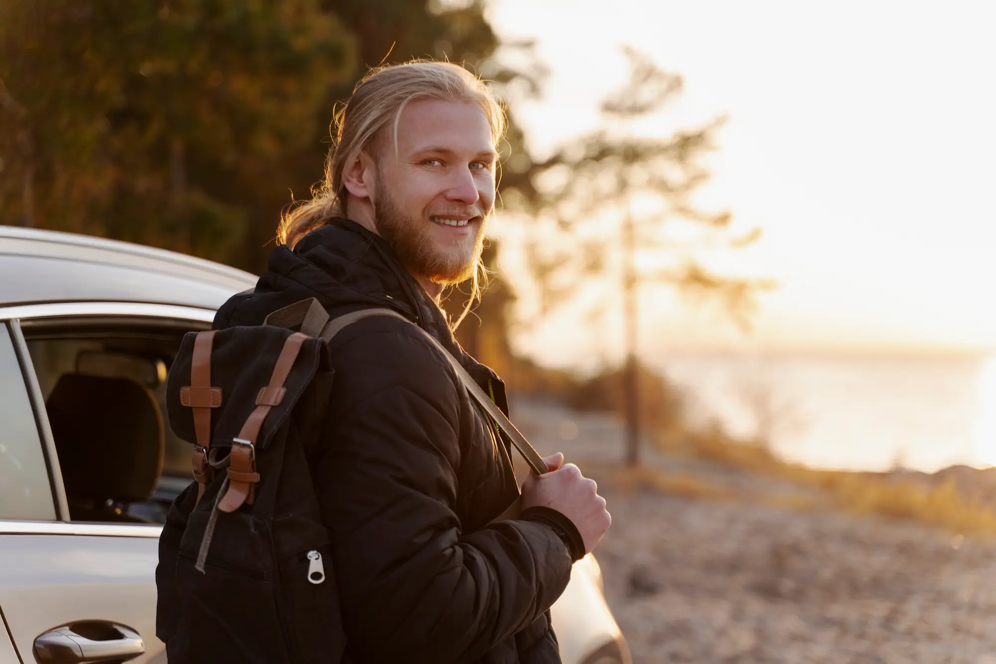 Smilende mann med ryggsekk utendørs, illustrerer viktigheten av gode bilder for Google Lens og visuelle søkeresultater.