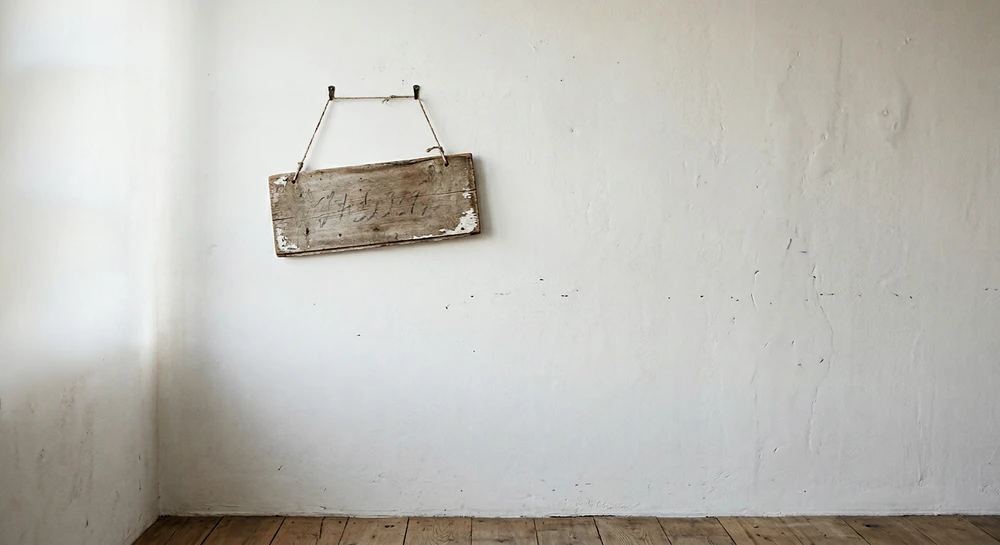 Et lite, slitt treskilt henger på en hvit vegg, symboliserer kanskje dårlig design.