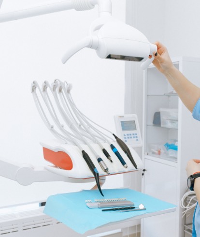 Dental handpieces and clinical instruments arranged beside a treatment chair
