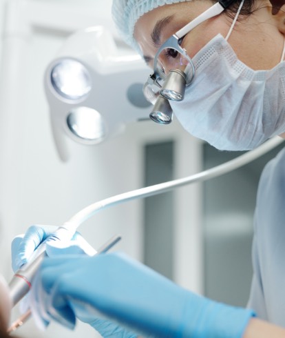 Dental professional providing close-up chairside care using clinical instruments and gloves
