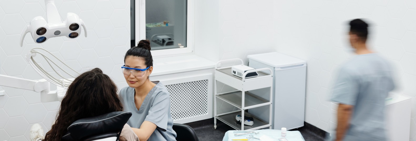 Dental professional consulting with a patient inside a modern treatment room