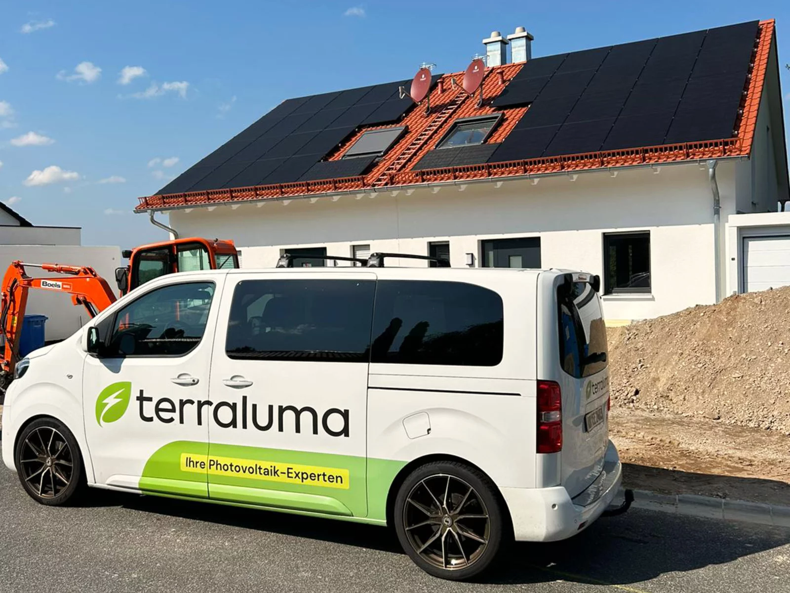 Firmenfahrzeug der terraluma GmbH vor Haus mit neu installierten Solarpanels