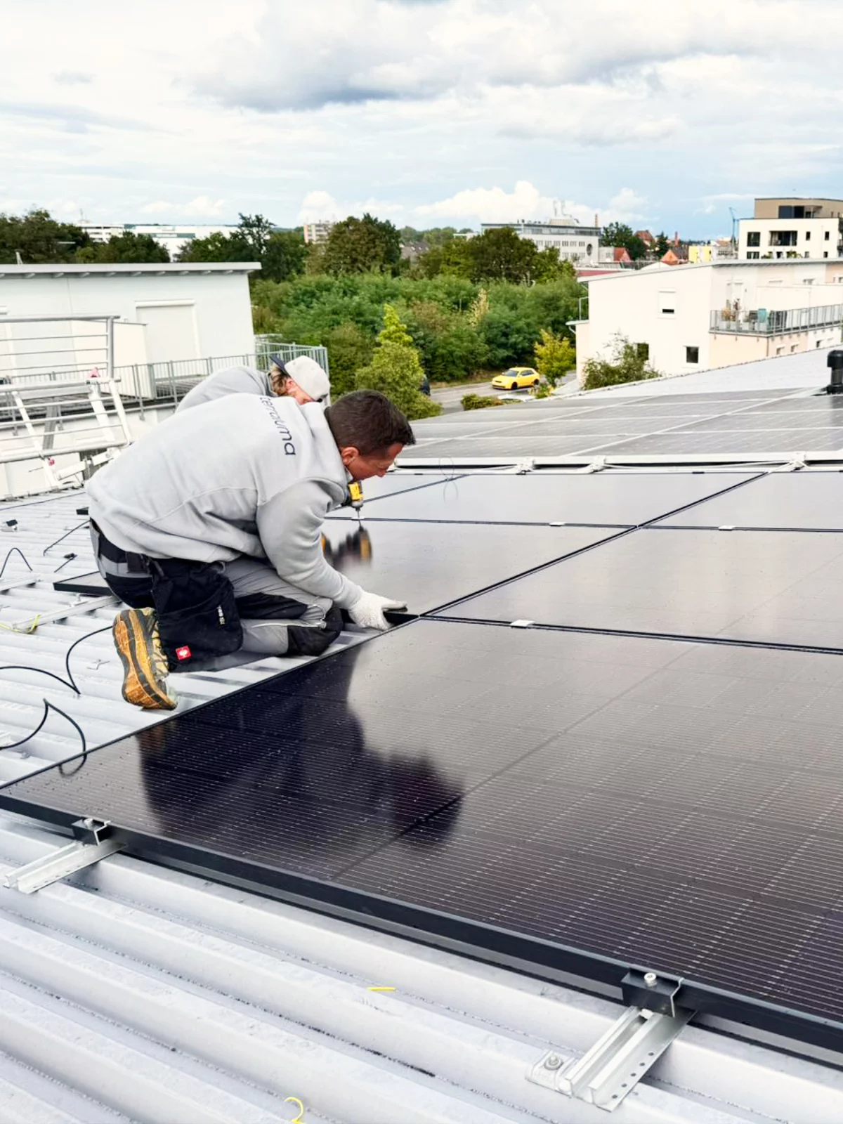 Techniker der terraluma GmbH installiert Solarmodule auf Metalldach
