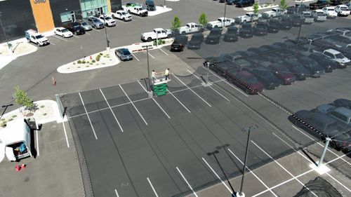 Aerial photo of hail netting being installed over cars in parking lot in Colorado