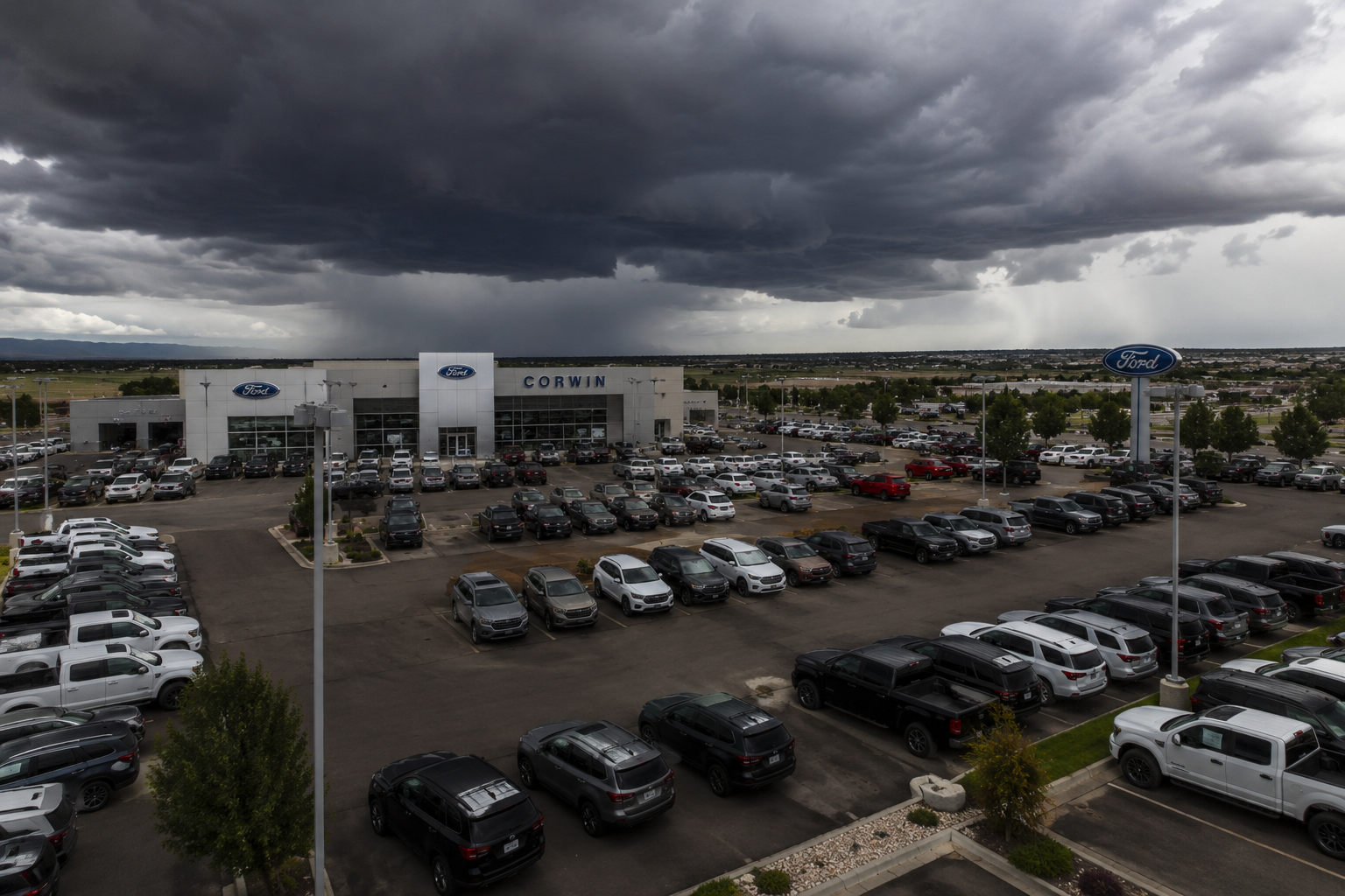 storm approaching a car dealership parking lot