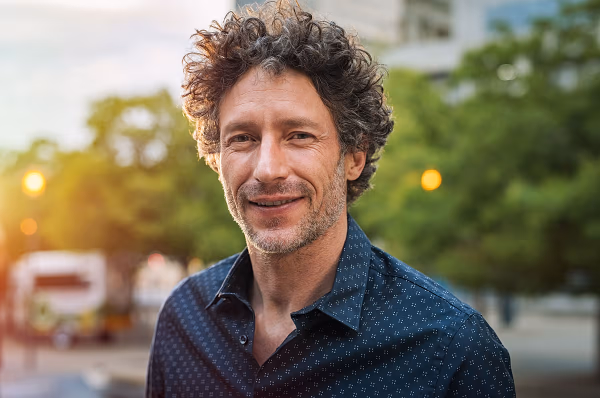 a handsome middle aged man smiling outside