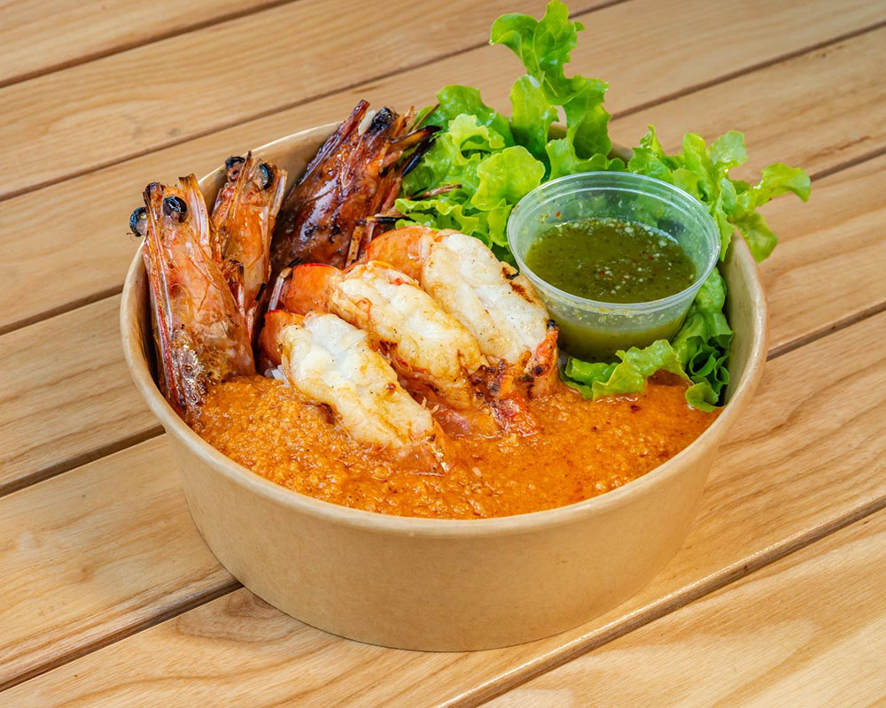 Grilled and peeled king prawns on rice with special topping sauce