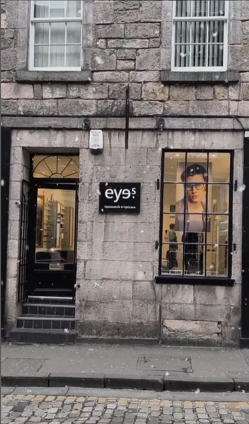 Eyes optometrist storefront with glasses display in stone building window