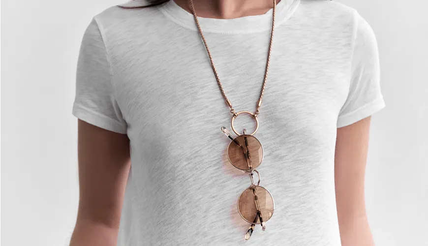 Rose gold necklace with layered circular pendants on white shirt