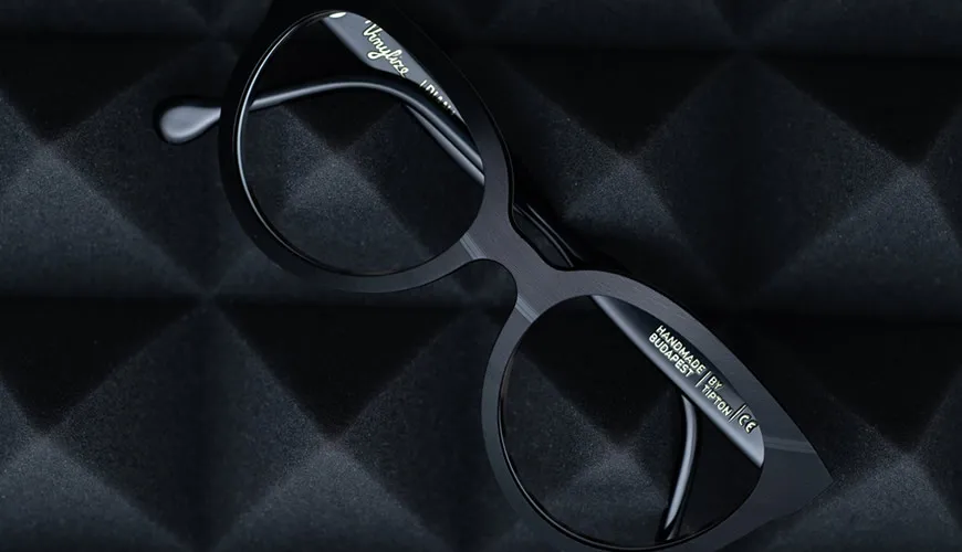 Black eyeglasses with sleek design resting on textured dark background