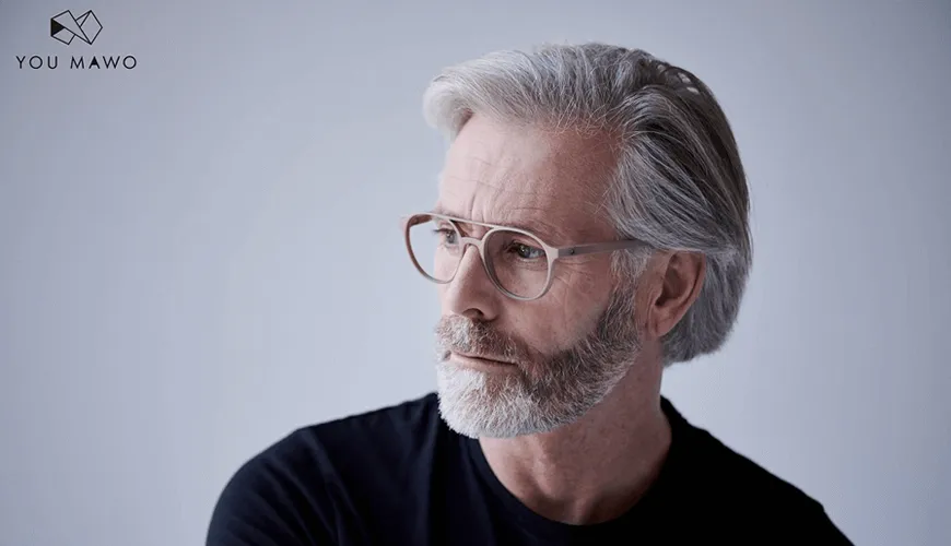 Mature professional with glasses and gray hair looking thoughtfully sideways