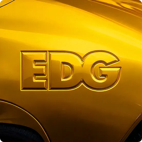 Embossed letters 'EDG' on a shiny yellow/golden surface next to a wheel arch.