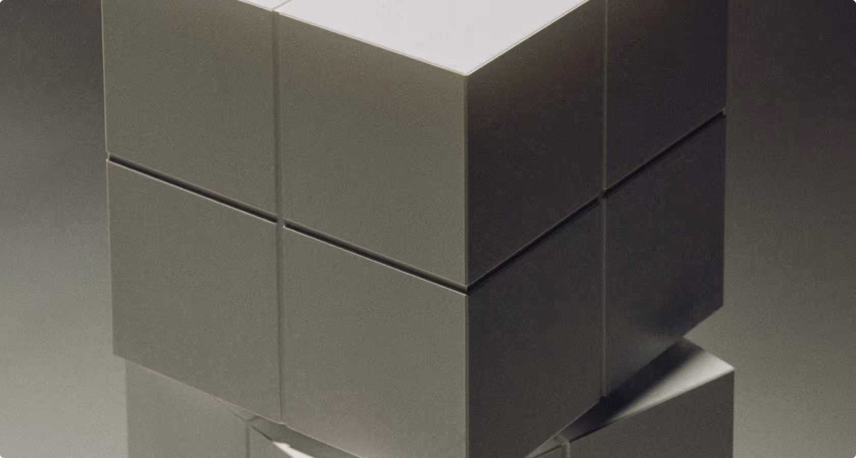 Close-up of an abstract geometric sculpture composed of stacked dark and light cubic blocks.