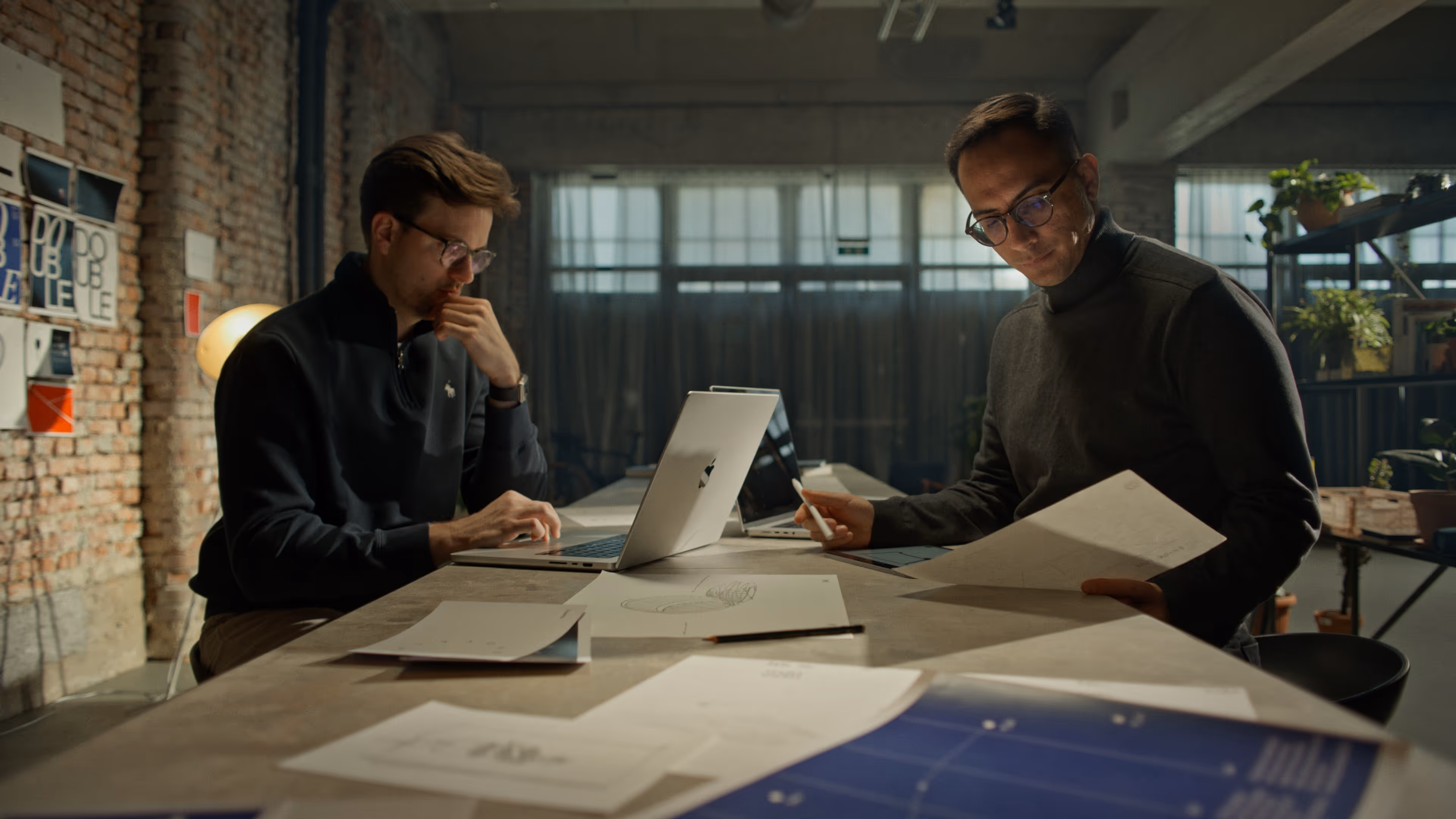 Two working man sitting at a shared desk office