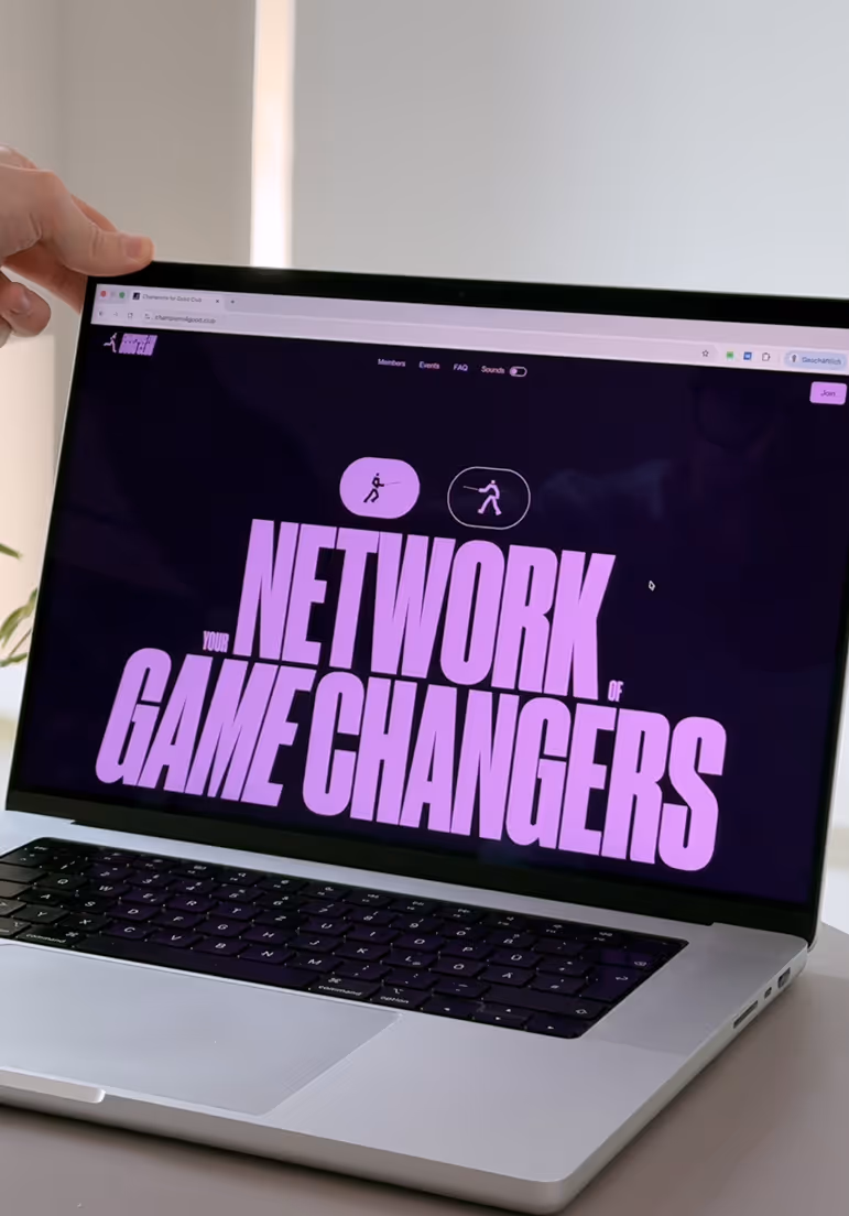 Laptop screen displaying 'Your Network of Game Changers' in large purple text on a dark background.
