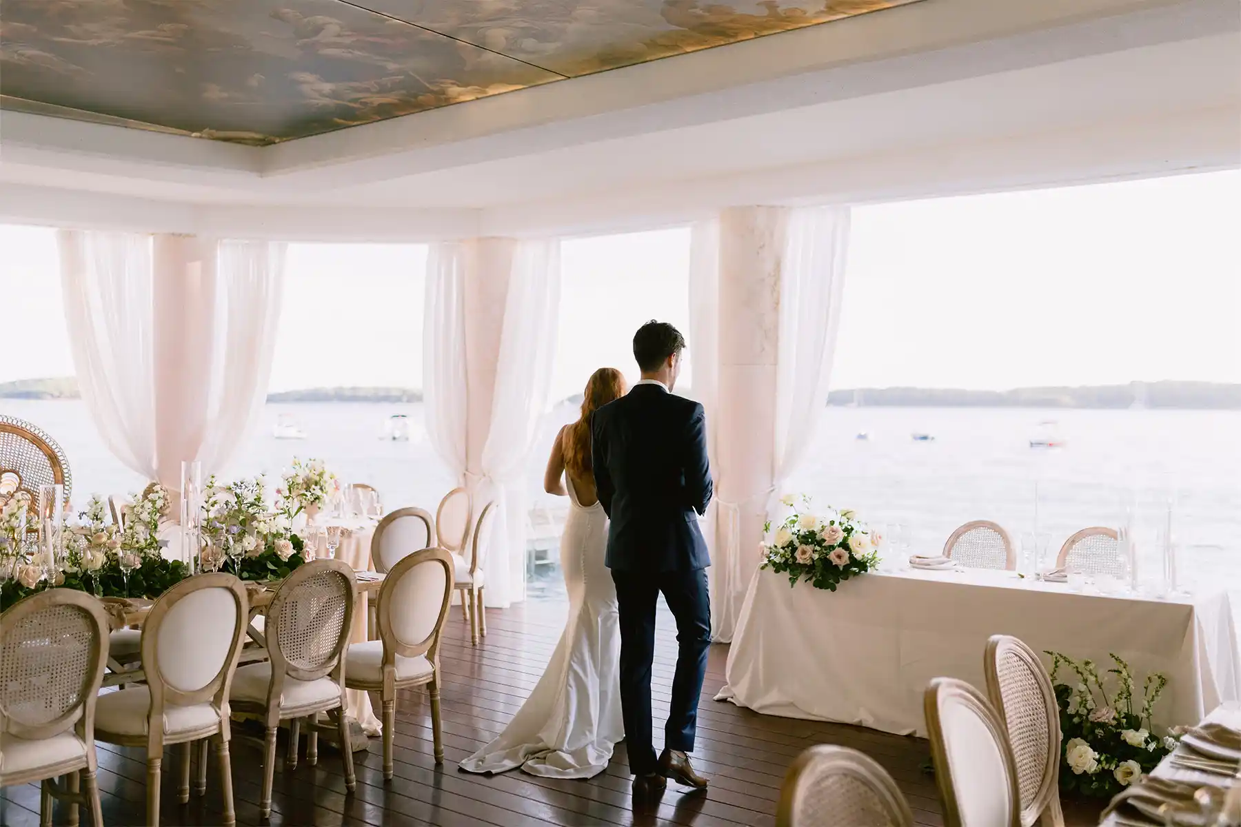Bride and groom from behind looking at Pakleni Islands from Beach Club Hvar reception salon